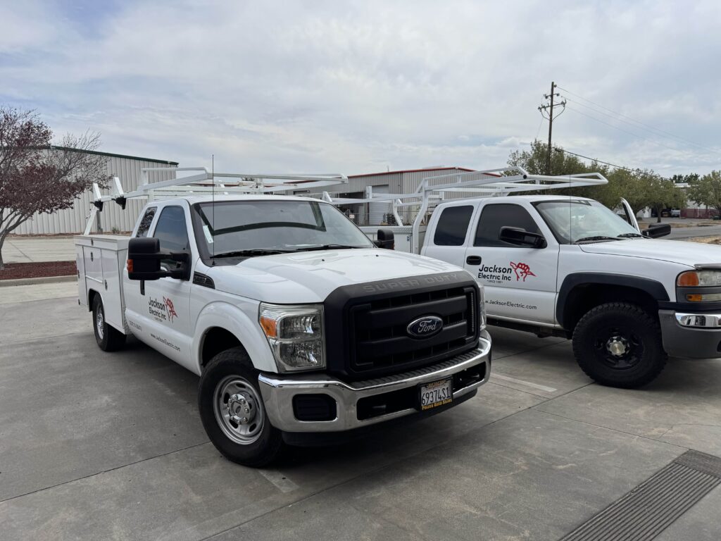 Two Jackson Electric work trucks with ladder racks