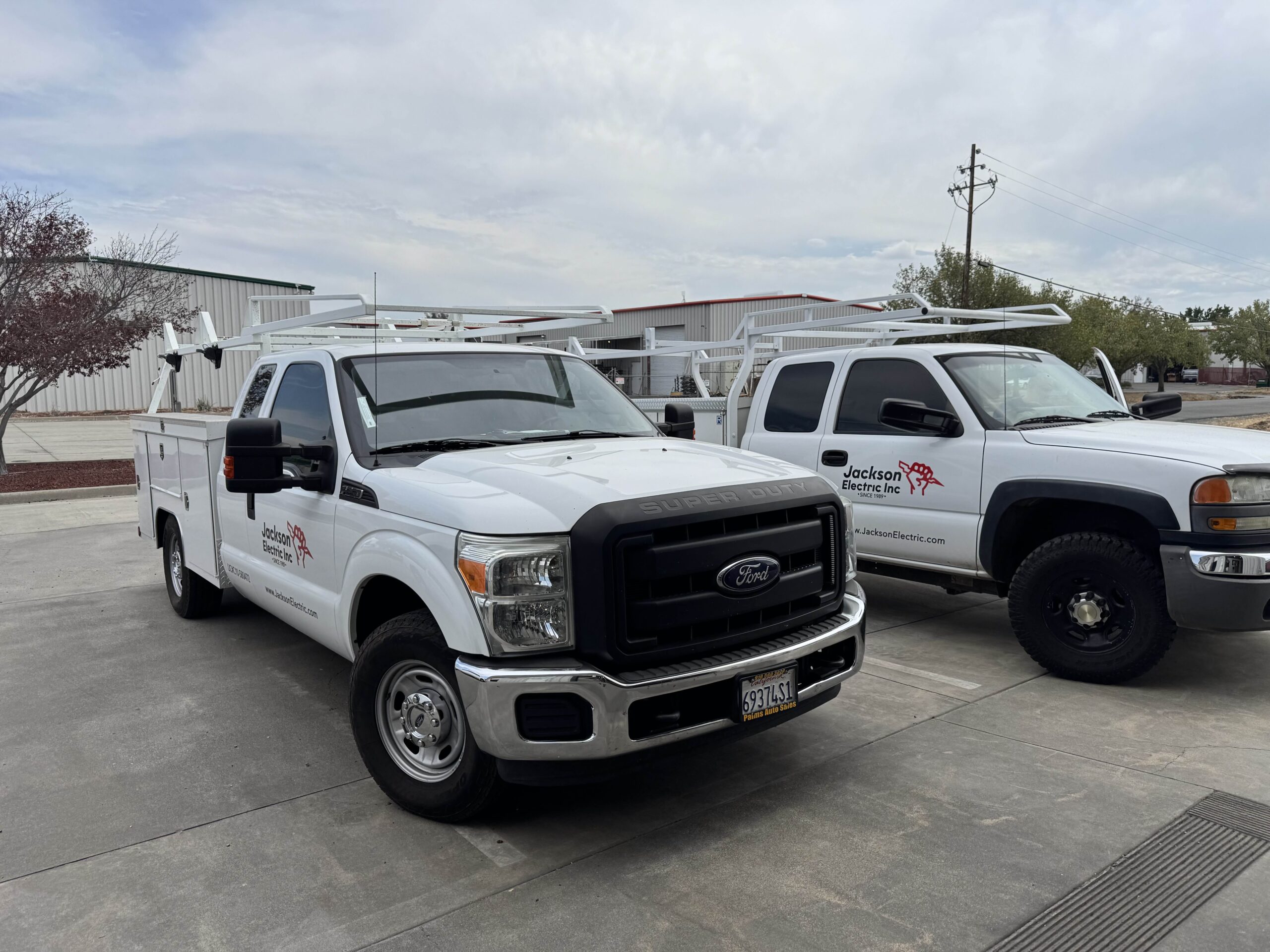 Two Jackson Electric work trucks with ladder racks