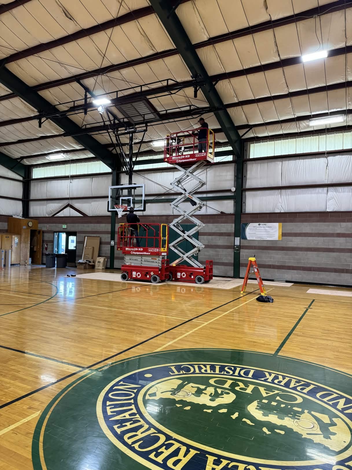 Lighting work using scissor lifts in a gymnasium